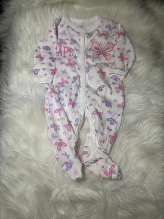 Baby onesie with butterfly pattern on a fluffy white surface